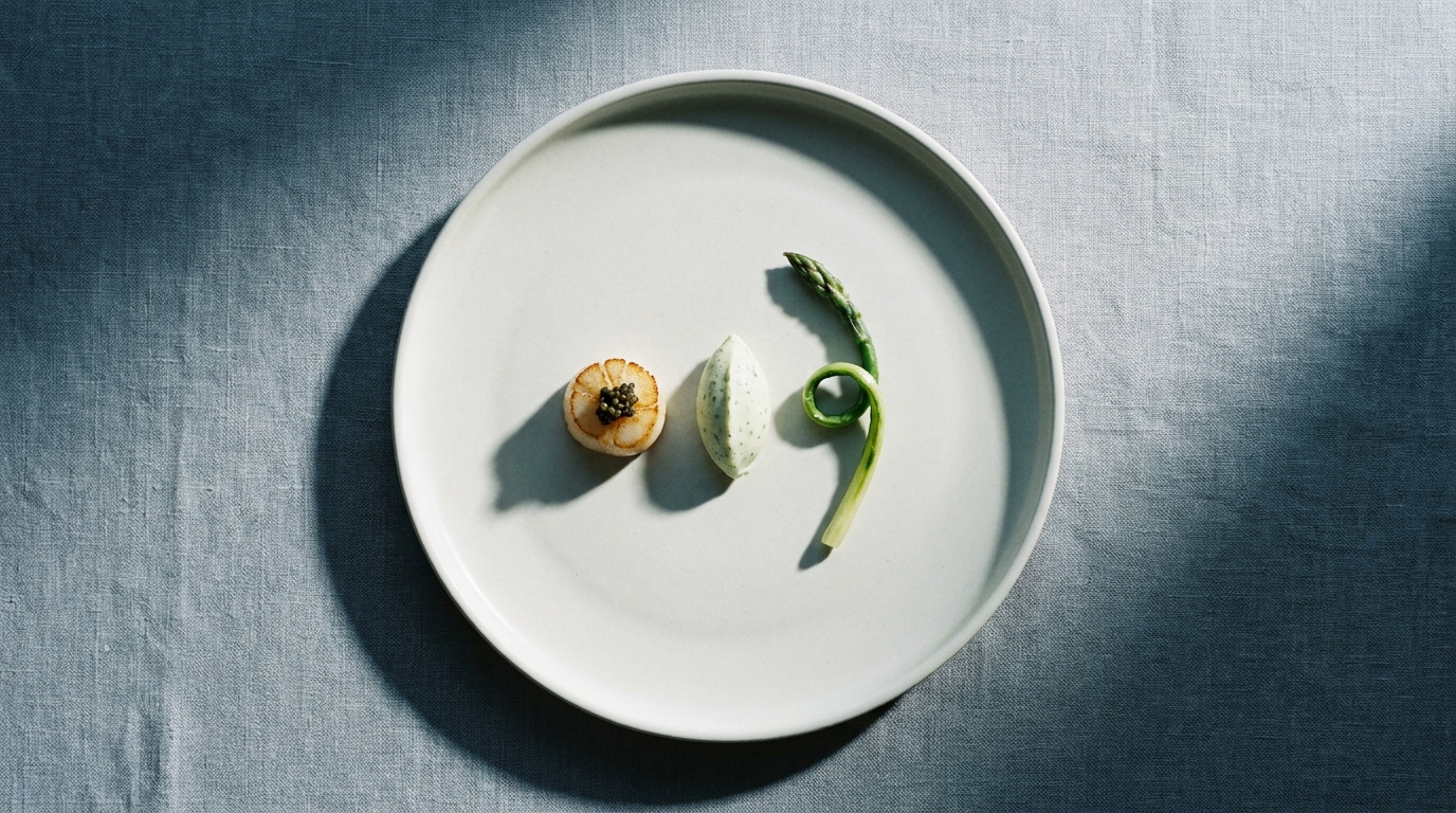 Fotografia food fine dining — capasanta con caviale e asparago su piatto bianco